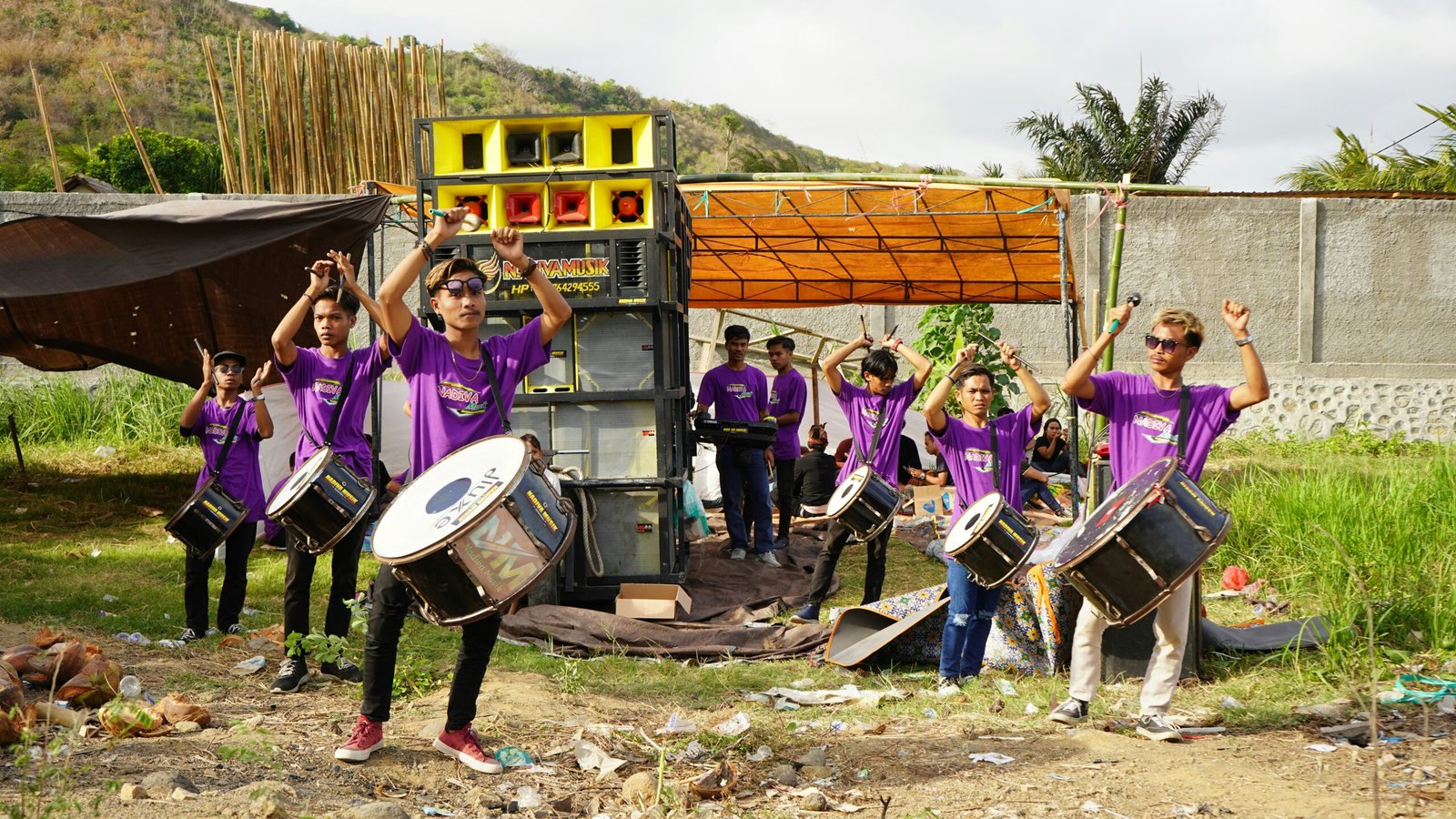 A group of people in purple shirts playing drums