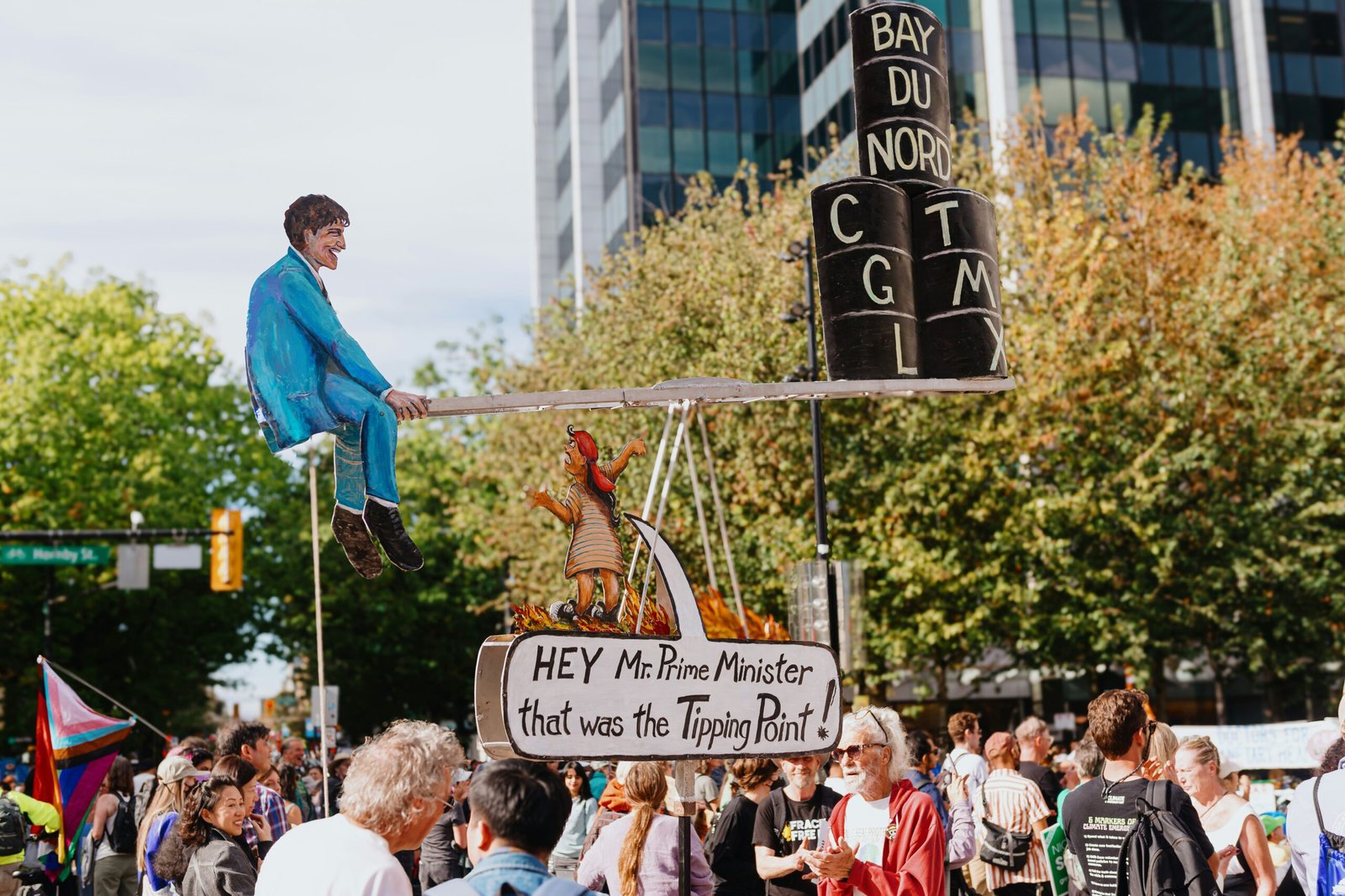 A man is sitting on top of a sign